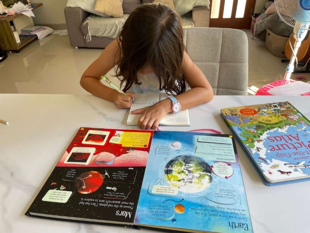 Young girl taking notes from a book before reading